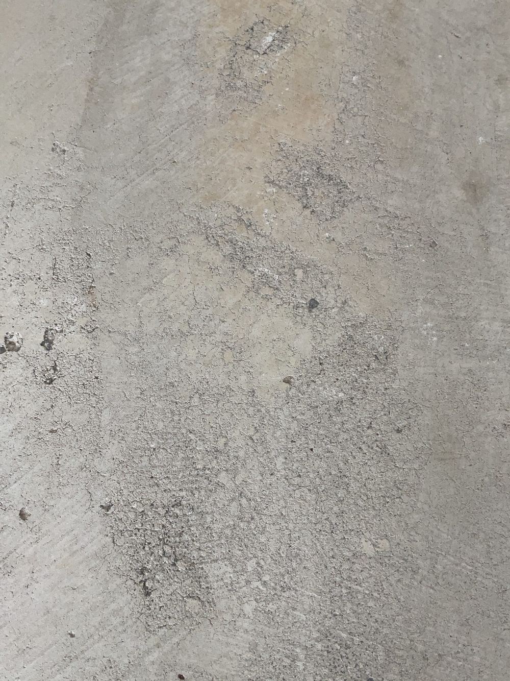 Damaged garage slab surface that will spall once cars use it, found during a pre-handover inspection in Tarneit